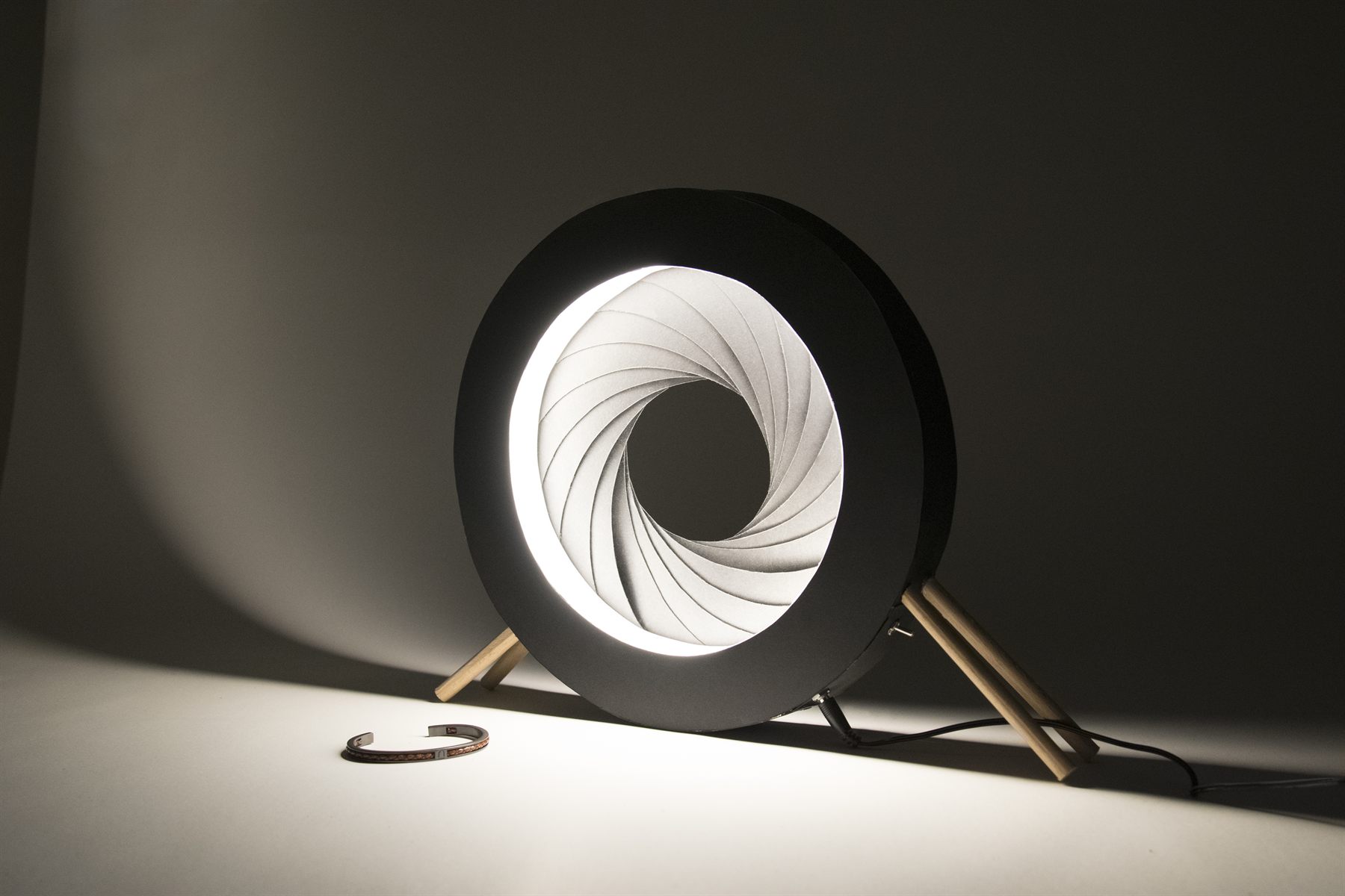 Luminaire de bureau en forme de diaphragme d'appareil photo, allumé, conçu par Benjamin Lhuillier