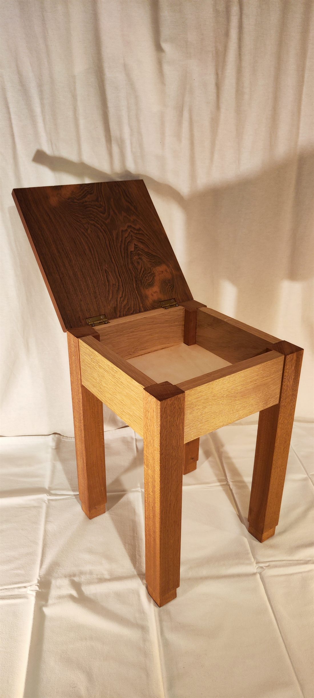 Le tabouret-coffre ouvert, révélant le rangement intérieur et les assemblages